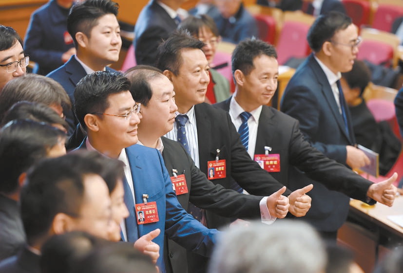 在市政协十四届三次会议会场，委员们合影时竖起大拇指，为市政协工作点赞。