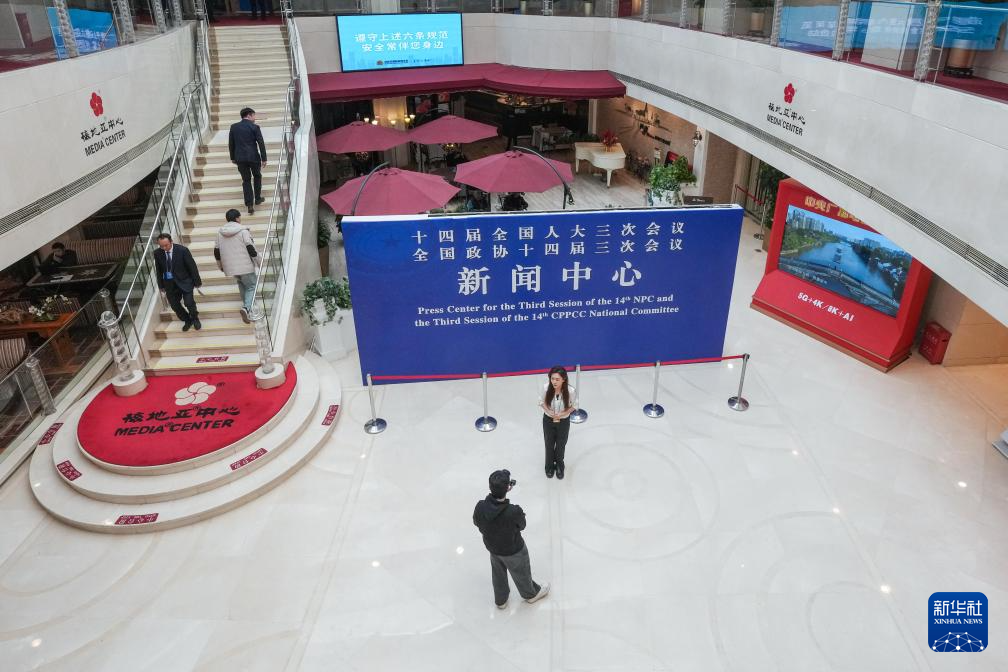 2月27日，媒体记者和工作人员在全国两会新闻中心忙碌。