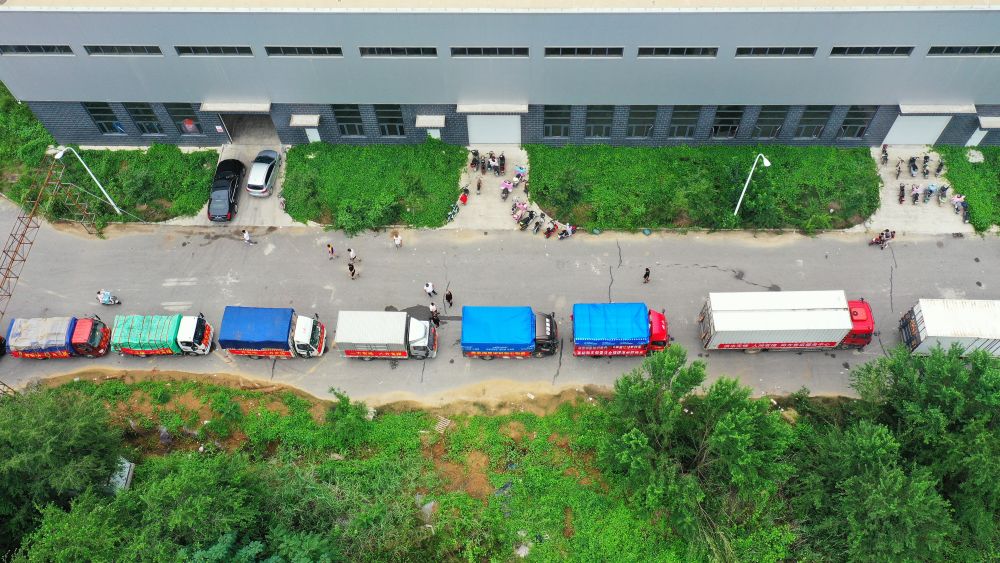 在河北省涿州市钢研物资储备点外，运送物资的车辆排起长队（8月5日摄，无人机照片）。