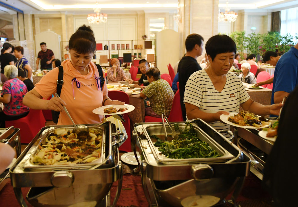 8月1日，北京市房山区青龙湖镇的村民在临时安置点用餐。