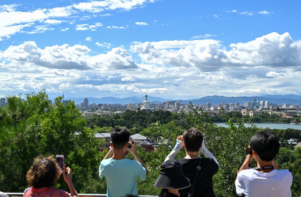 2024年8月12日北京天气晴好，游客从景山上拍摄远处的北海公园。