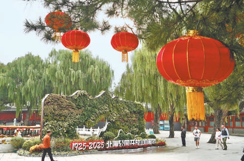 北海公园立体花坛布置大量色彩丰富的花卉绿植，市民游客在花坛旁游览、锻炼。