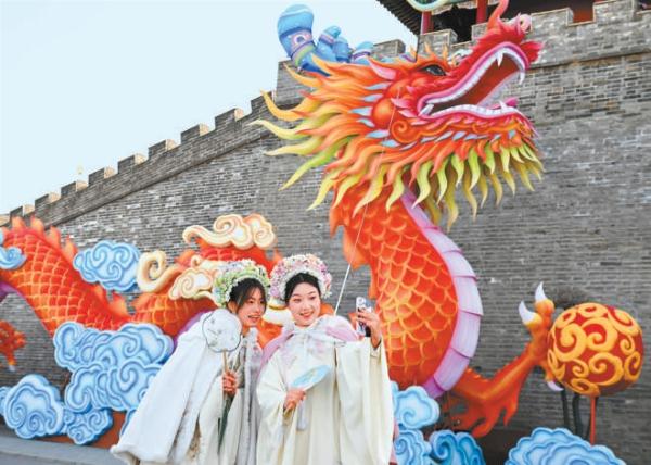 1月24日，游客在河北省石家庄市正定古城南城门花灯前拍照。春节将至，京津冀各地年味渐浓，呈现出红红火火迎新春的喜庆氛围。