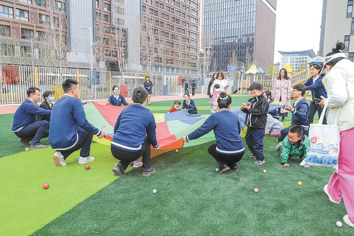 雄安白塔幼儿园内，幼儿教师带领儿童做游戏。