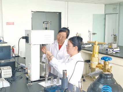 在华美孚泰公司，邸博士（右）正在和同事做实验。