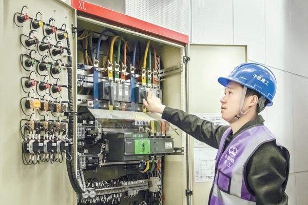 中铁建工集团城市副中心图书馆项目部电气班组班长李泰，凌晨五点在北京城市图书馆内巡查。