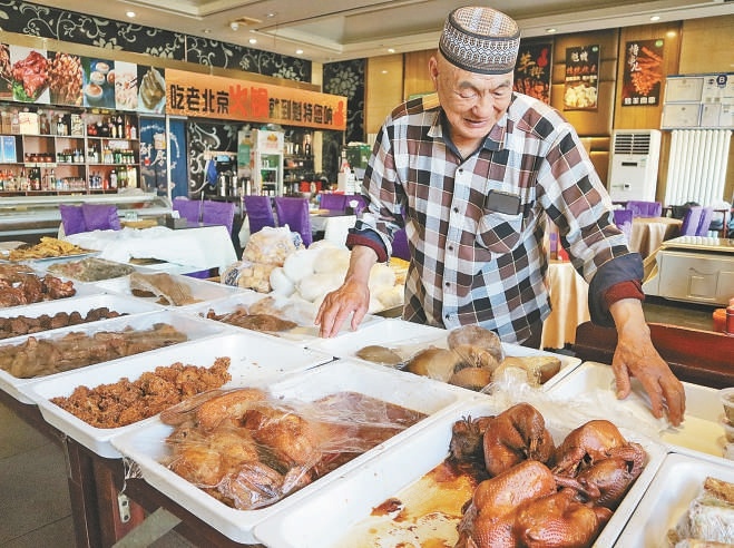 魁特饭庄掌柜马洪玉正在介绍熟食。