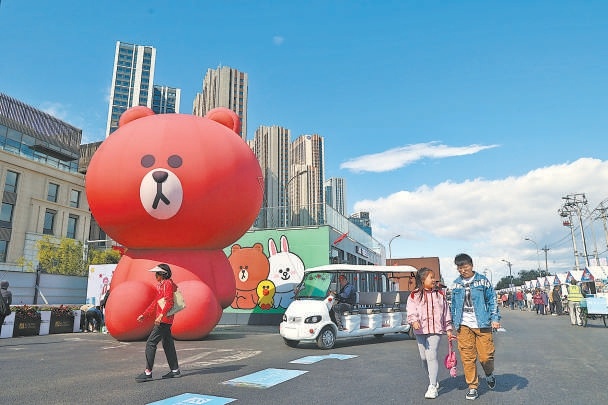步行街两侧摆满了各类美食、文创摊位，还有小型体育公园吸引孩子们来运动。