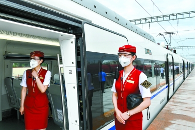 6月30日早晨，在良乡站站台，乘务员在车门口迎接乘客。