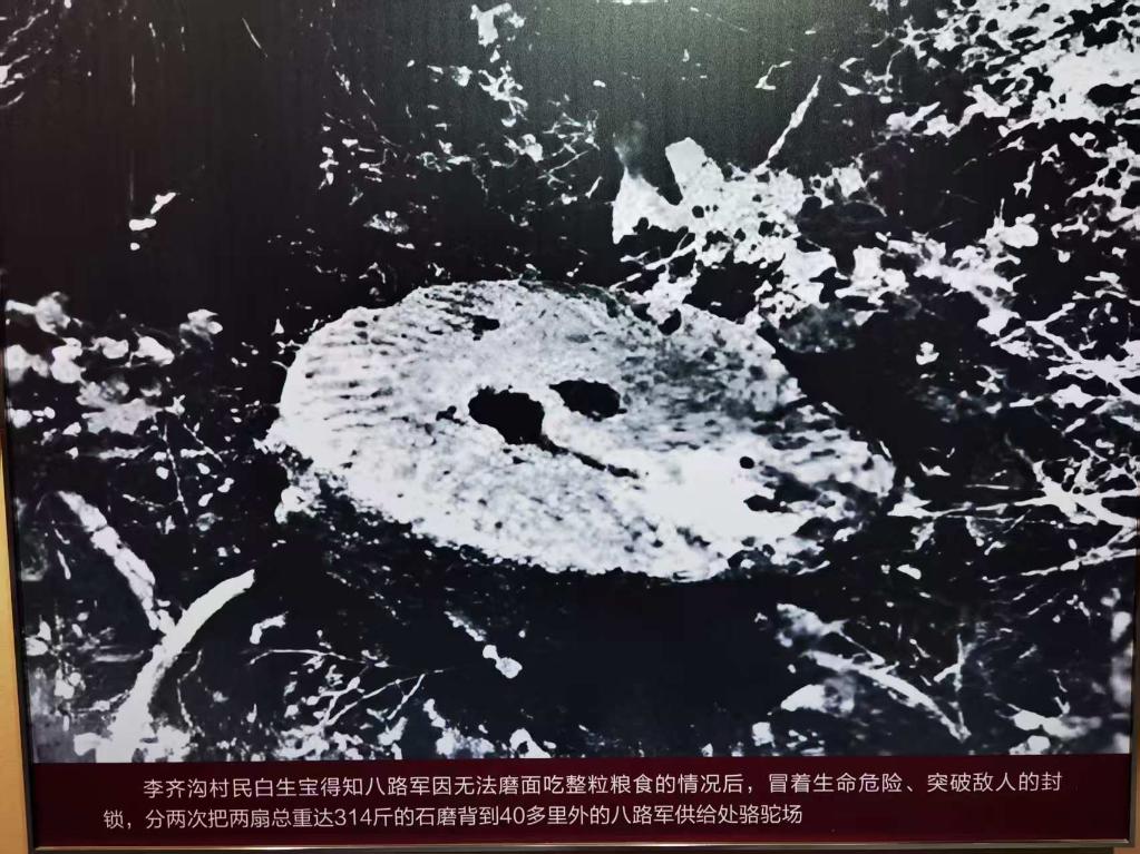 图为大青山抗日游击根据地展馆内展示的石磨图片。