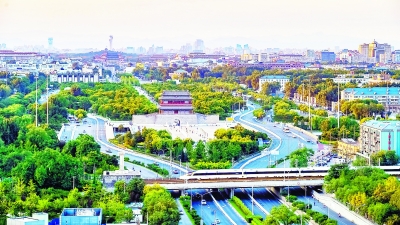从沙子口向北望，京津城际复兴号飞驰而过，与2004年恢复的北京中轴线标志之一的永定门城楼相得益彰。