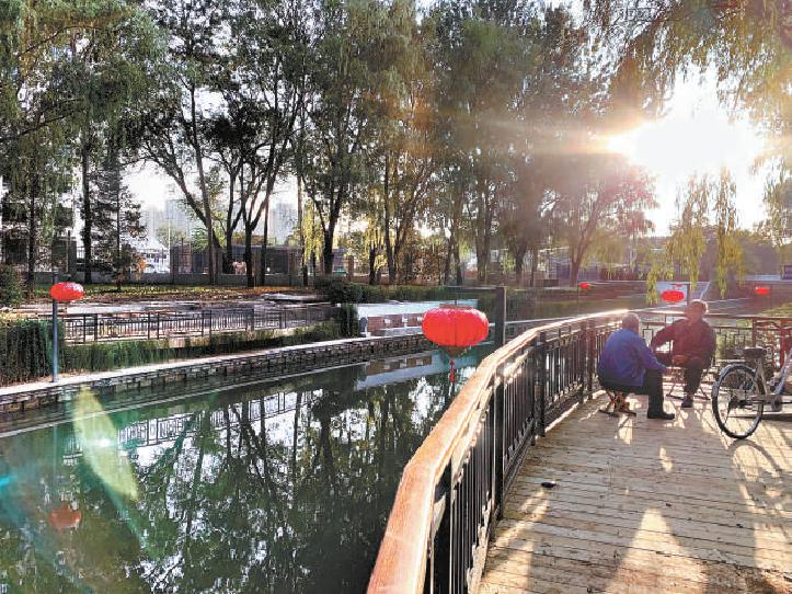 图为五塔寺路附近的居民在河边休憩
