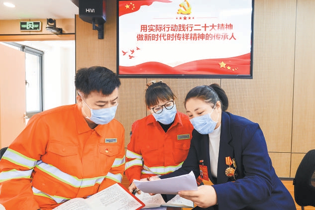 党的二十大代表、北京东城环卫职工李萌向单位同事传达党的二十大精神。