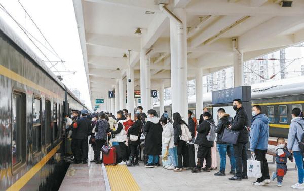 2月13日，在成都西站，旅客排队登上临客K4618次列车。这是2023年春运期间从成都出发的最后一趟增开临客列车。据悉，中国铁路成都局集团有限公司在春运期间共开行35组、3492列临客服务短途旅客和务工人员返乡、外出。