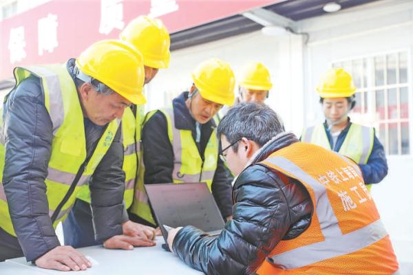 1月12日，在中铁上海工程局合肥轨道交通8号线项目部，志愿者帮助务工人员网购返乡火车票。