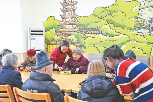 1月22日，在宁波市镇海区金生怡养院，护理员陪着失能老人在休闲区玩益智游戏。2023年1月，宁波率先实现长期护理保险全域覆盖，全市所有区域医保参保人全部被纳入保障范围，提供机构护理和居家护理两种选择。