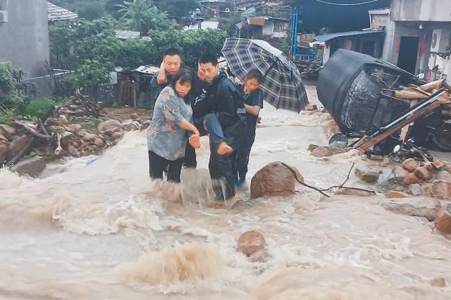 6月13日，福建省福清市公安局一都派出所民警冒雨将被困老人转移至安全地带。