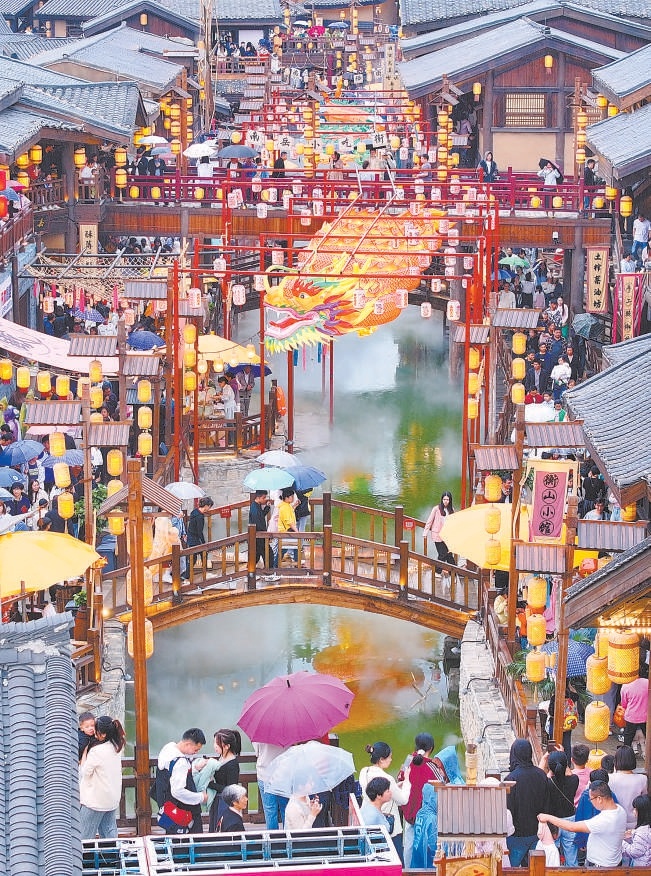 游客在湖南省衡阳市南岳区“南岳里”庙会民俗美食街区游玩，乐享假日美好时光。