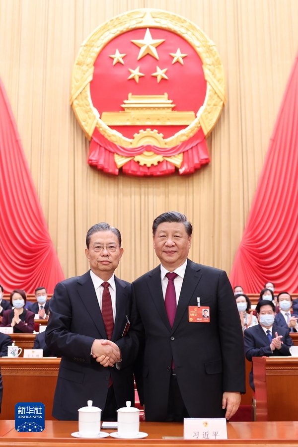 3月10日，十四届全国人大一次会议在北京人民大会堂举行第三次全体会议。习近平全票当选中华人民共和国主席、中华人民共和国中央军事委员会主席。这是习近平同新当选的全国人大常委会委员长赵乐际握手。