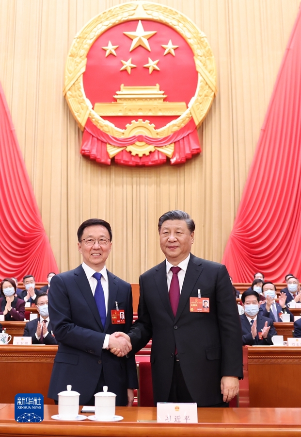 3月10日，十四届全国人大一次会议在北京人民大会堂举行第三次全体会议。习近平全票当选中华人民共和国主席、中华人民共和国中央军事委员会主席。这是习近平同新当选的国家副主席韩正握手。